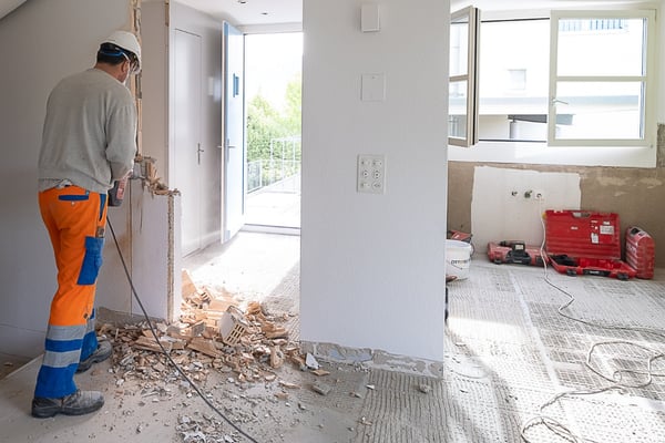 Ein Schmid Bauarbeiter Spitz ein Wanddurchbruch um den Eingangsbereich zu verbreitern.