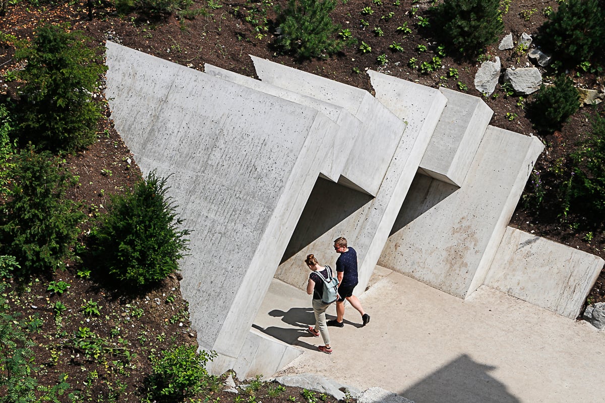 2 Personen betreten Eingang Felsenwelt aus Sichtbeton im Gletschergarten in Luzern.