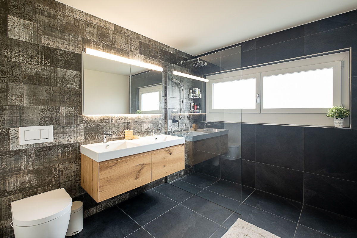 Badezimmer modern umgebaut, mit Waschbecken und offene Dusche.