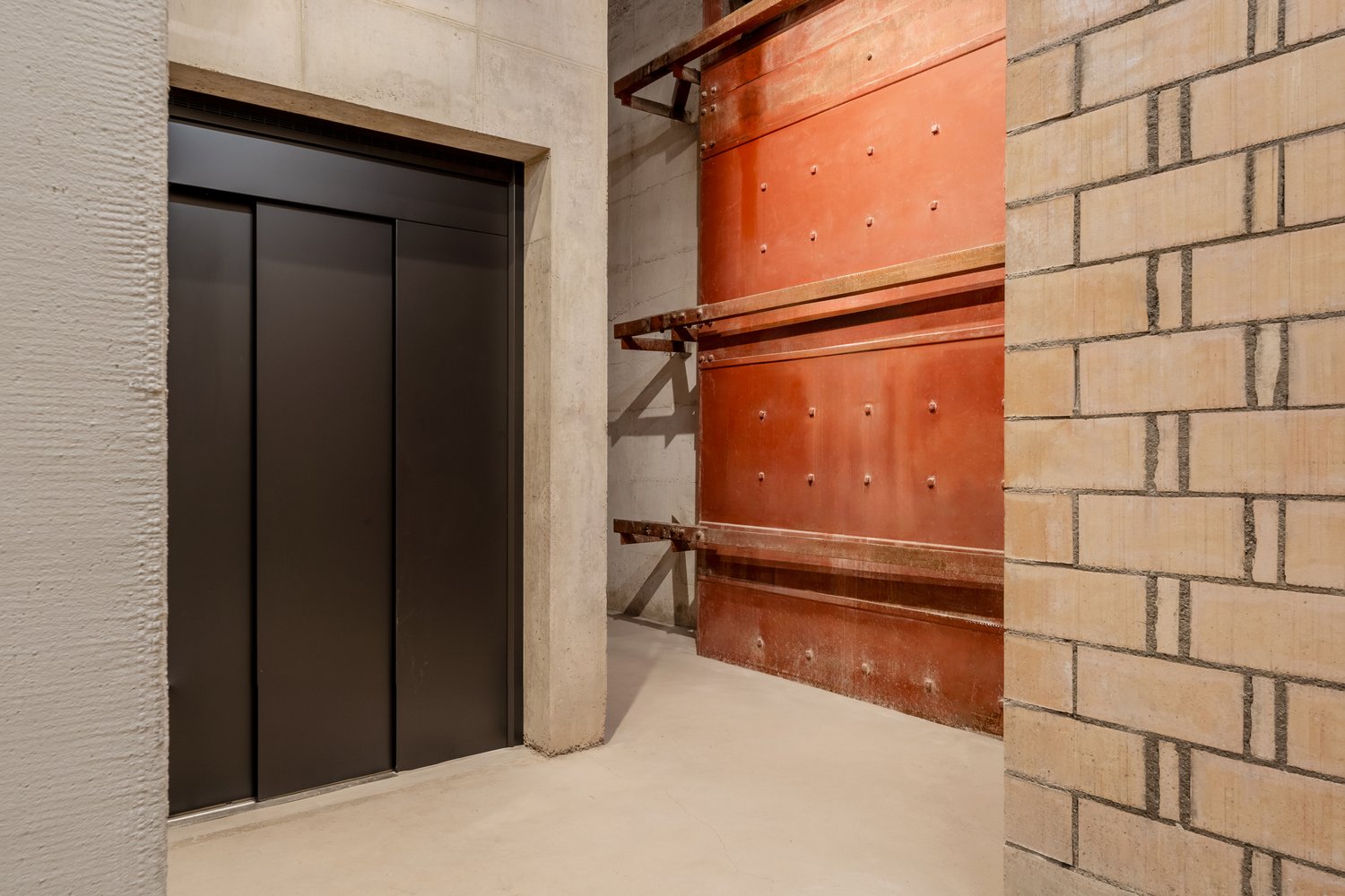 Lift im Treppenhaus mit Sichtbeton und Sichtmauerwerk