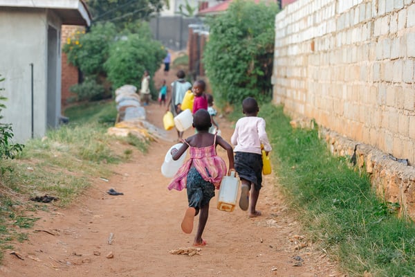 Kinder in Afrika die Wasser holen.
